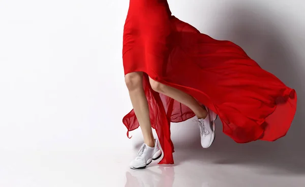 Sport Frauenbeine in Turnschuhen laufen in Mode rotes Kleid windig auf weiß — Stockfoto
