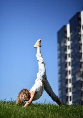 Şehir merkezindeki şehir parkında yoga germe egzersizleri yapan genç bir kadın.