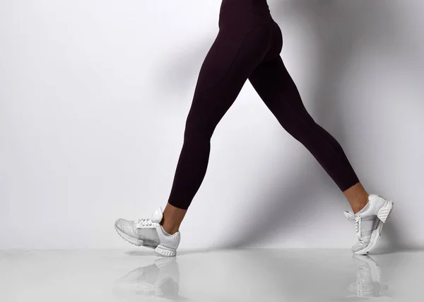 Young athletic woman brunette girl in a good shape in trendy sportswear walking in gym uniform does cardio exercises — Stock Photo, Image