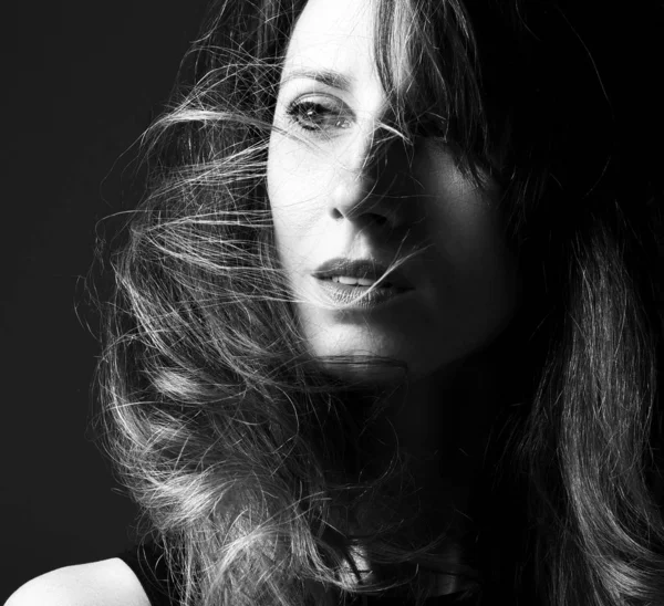 Black and white fashion art studio portrait of beautiful elegant woman with windy hair