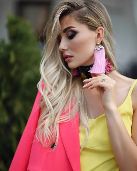 Mujer rubia joven exitosa en traje de chaqueta rosa moderna y blusa amarilla — Foto de Stock