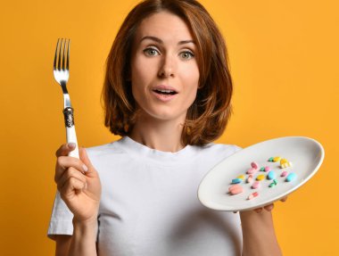 Diyet takviyeleri ile çatal ve beyaz plaka ile Kadın beslenme farklı renk hapları kilo kaybı ilaçlar onları almak için nasıl söyler