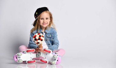 Paten çocuk kız ücretsiz metin kopyalama alanında yerde oturur waffle koni büyük ve lezzetli dondurma tutar