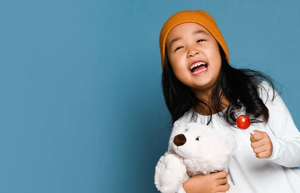 stock image Asian girl kid hold polar bear toy and lollipop candy happy smiling screaming