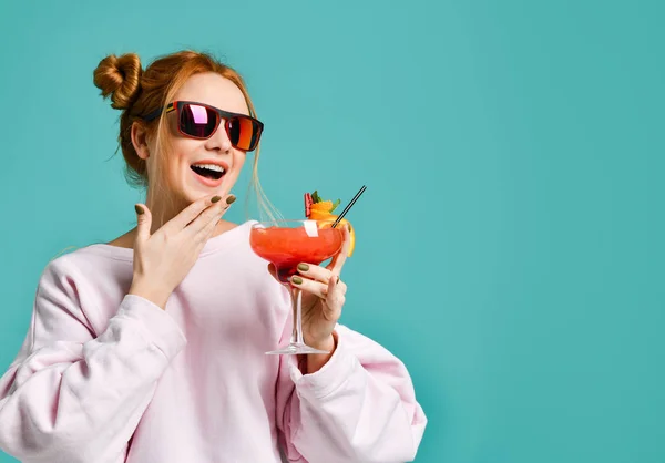 Neşeli clubbing genç kadın tropik kokteyl çilek margarita ile sohbet arkadaşları ve parti sırasında gülüyor — Stok fotoğraf