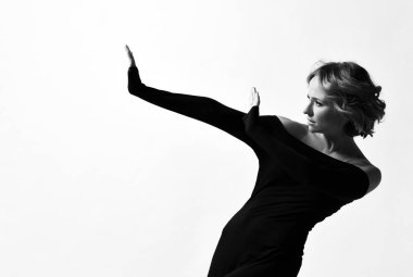 Beyaz poz ekstra uzun kollu şık siyah elbise kısa kıvırcık sarı saçlı genç kadın oyuncu