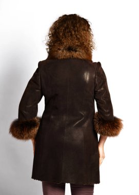 Kürk yakalı kısa kahverengi koyun derisi palto ve beyaz uzun kıvırcık kızıl saçlı kadın tarafından giyilen dörtte üçü kollu