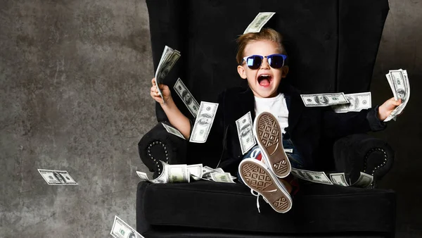 Happy young boy crazy screaming excited hold stack of dollars money. Guy celebrates success lots of money dollar bills