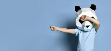Çokgen panda maskesi erkek çocuk mor arka plan üzerinde elleri ile yakın gözleri dans