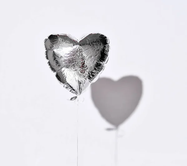Party jest ponad przebicia Silver Heart balon obiekt na białym szarym tle z cienia — Zdjęcie stockowe
