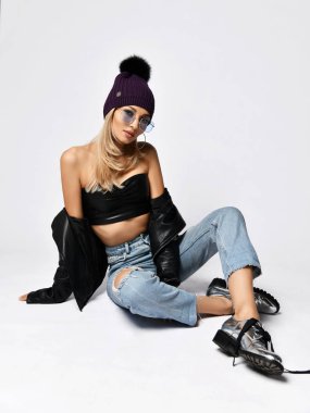 Mavi kot deri ceket ve mor kış şapka oturan genç grunge tarzı kadın Moda sanat fotoğrafı