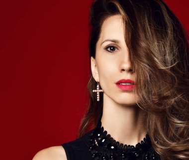 Güzel kadın moda stüdyosu portresi, rüzgarlı saçlar, kırmızı küpe. 