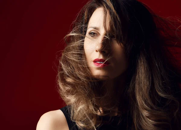 Красива жінка студія моди портрет з вітряним волоссям сучасна сережка на червоному — стокове фото