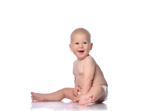 Retrato en perfil de bebé bebé feliz en pañal sentado mirando algo cerca de él en el espacio de copia en blanco —  Fotos de Stock