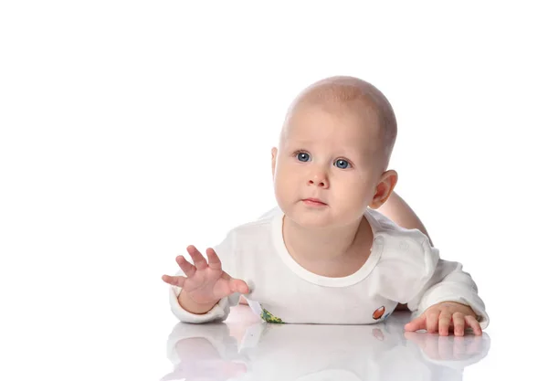 Peaceful quiet child baby toddler in white bodysuit is crawling our way lying on his stomach on white — Stock Photo, Image