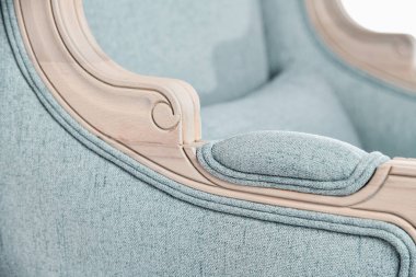 Modaya uygun modern retro pastel açık mavi koltuk, ahşap ile yakın plan detayları. Mobilyalar, iç nesneler, şık koltuklar. 