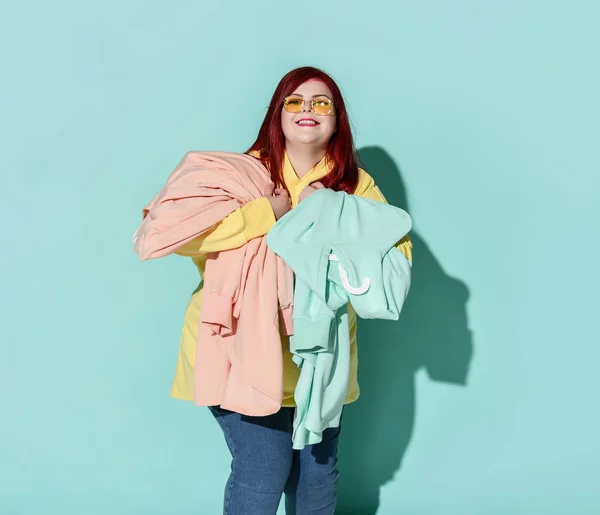 Jong gelukkig glimlachen overgewicht vrouw in casual kleding houdt gespen knuffels blauw en roze hoodies — Stockfoto