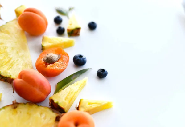 Ganze und halbierte Aprikosen, Beeren, Ananasscheiben sind überweiß. Bio-Superfood-Konzept für gesunde Ernährung — Stockfoto