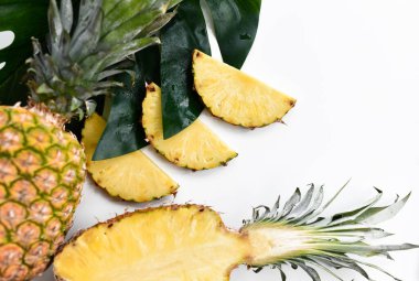 Büyük tropikal yaprağın ortasında dilimlenmiş ananas. Sağlıklı yemek için organik süper gıda kavramı