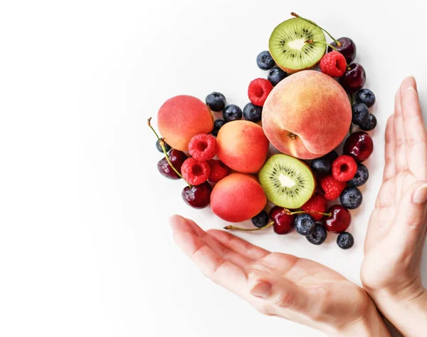 Corazón hecho de frutas y bayas está bordeado con las manos de la mujer. Concepto de superalimento orgánico para una alimentación saludable —  Fotos de Stock