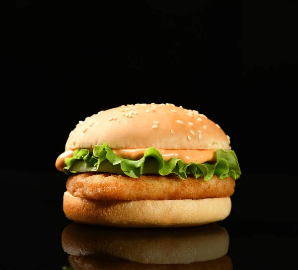 Świeży smaczny burger ze smażonym indykiem świeżej sałatki i specjalny sos na czarnym tle — Zdjęcie stockowe