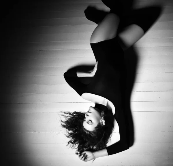 Linda jovem morena encaracolado mulher em roupa interior do corpo e preto meias altas deitado no chão com os olhos fechados e sonhando — Fotografia de Stock