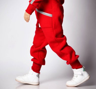 Kırmızı tulumlu şirin bir çocuk portresi ve yanımızdan geçen beyaz spor ayakkabılar.