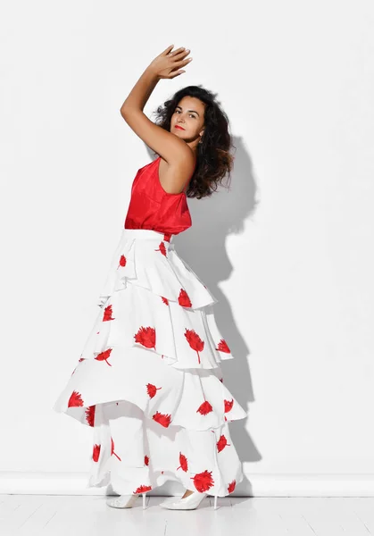Herrlich lächelnde hispanische Tänzerin in rot-weißem Kleid mit Blumenmuster tanzt Flamenco Carmen klatscht in die Hände — Stockfoto