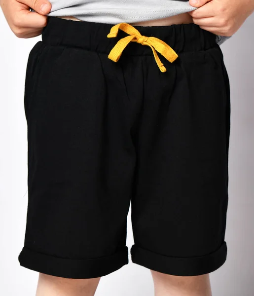 Närbild av barn i svarta shorts. Framifrån — Stockfoto