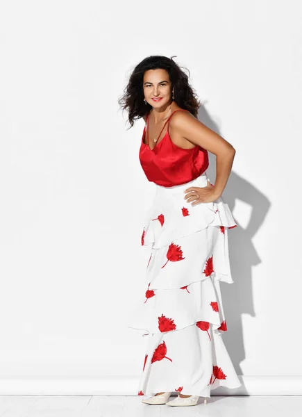 Wunderschöne hispanische Tänzerin im rot-weißen Kleid mit Blumenmuster tanzt Carmen Flamenco, die Hände auf den Hüften haltend — Stockfoto
