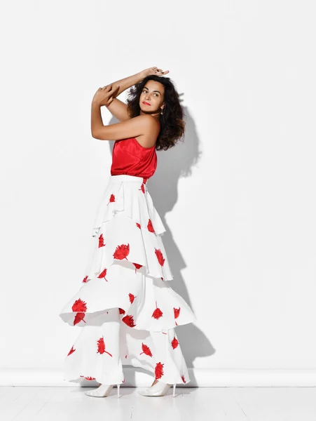 Wunderschöne spanische Tänzerin in rot-weißem Kleid mit Blumenmuster tanzt Flamenco Carmen hält die Hände am Kopf — Stockfoto