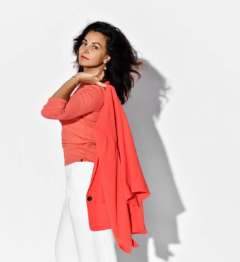 Şık, zarif, takım elbiseli, ceketli bir kadın. Omuz omuza duruyor. Profilden bize bakıyor.