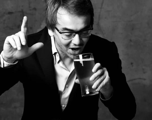 Retrato en blanco y negro del hombre con elegante chaqueta oficial de ropa y camisa de beber va a hacer un sorbo de bebida sabrosa de vidrio —  Fotos de Stock
