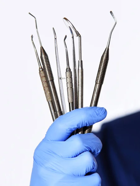 Zbliżenie rękawic dentystycznych z narzędziami dentystycznymi sondy przyzębia, lusterka, kielnie, żelazka, korkociąg — Zdjęcie stockowe