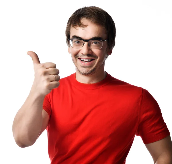 Porträt eines lächelnden erwachsenen Mannes mit Brille und rotem T-Shirt, der vor weißem Hintergrund mit erhobenem Daumen gestikuliert. Ausdrücken — Stockfoto