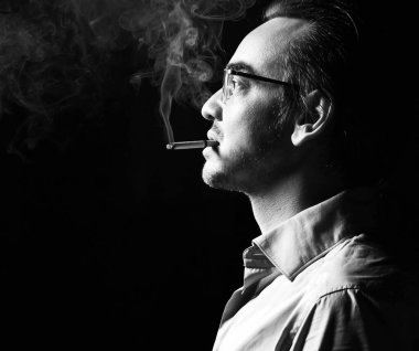 Resmi gömlekli ve gözlüklü acımasız iş adamı köpekbalığı portresi ağzında sigarayla duruyor. Yan görünüm