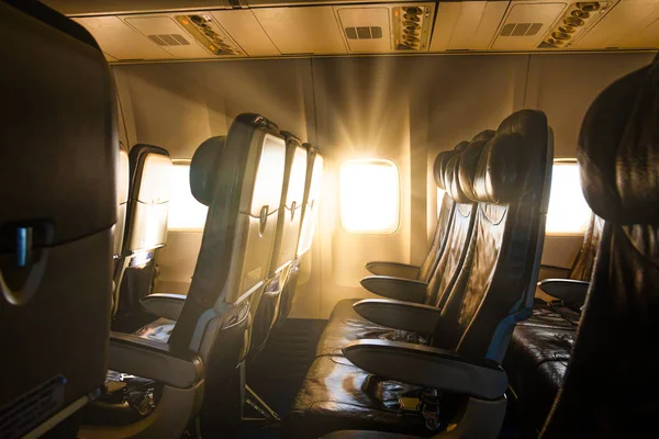 Empty airplane seats in the cabin in sunset light