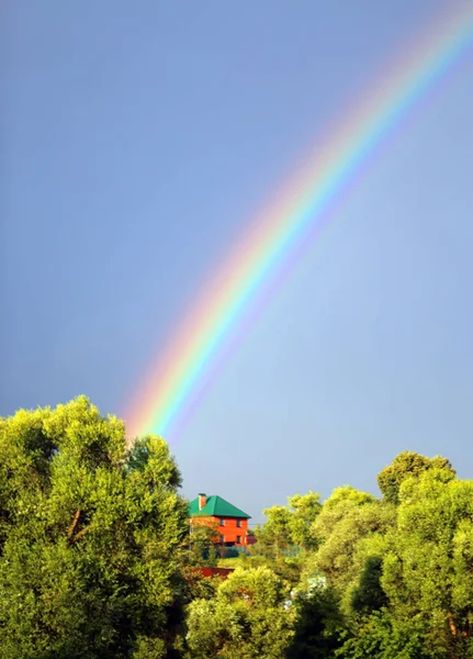 Prachtige kleurrijke regenboog in de blauwe hemel — Stockfoto