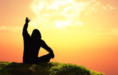 Bir adamın silueti peyzajın arka planına dayanır.