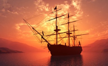 Günbatımında denizde eski bir yelkenli.