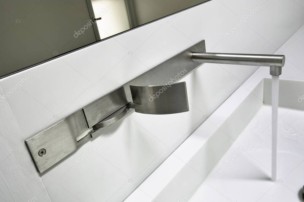 details of a modern steel water tap for a washbasin in the modern bathroom