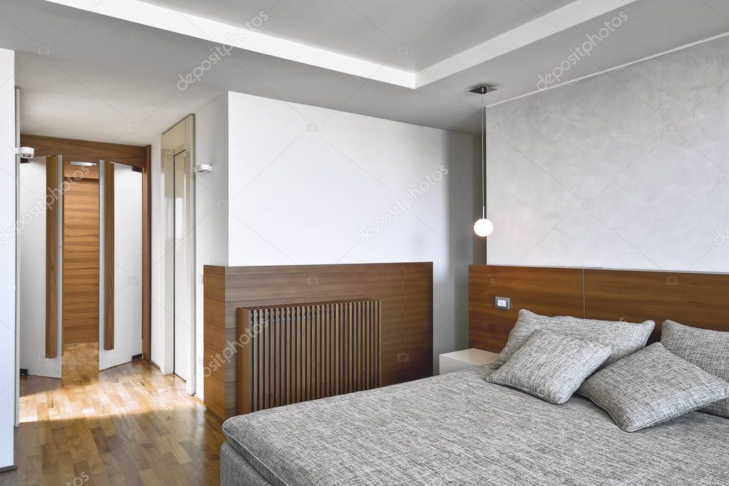 interiors shots of a modern bedroom with wooden floor and modern chandeliers