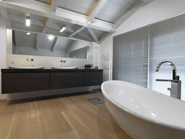 在阁楼房间的一个现代化的浴室的内饰拍摄木制天花板和木地板两个顶部的木制计划和独立的浴缸在中心 — 图库照片