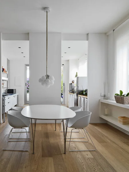 现代化的用餐室内部拍摄 配有白色桌子和白色椅子 所有客房都俯瞰着厨房 地板由木材制成 — 图库照片