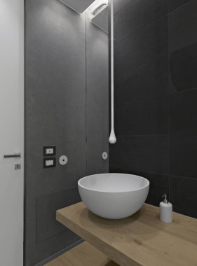 Ön planda tezgahın üstündeki lavabo ahşap planda dinleniyor.