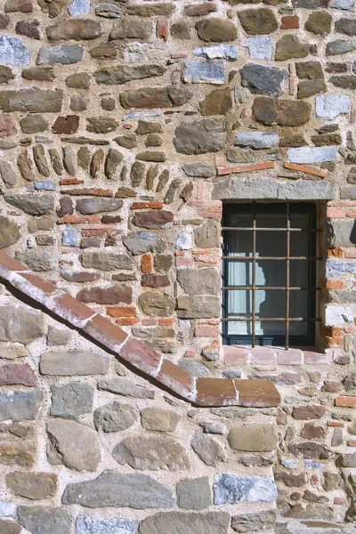 foreground the stone wall with little window