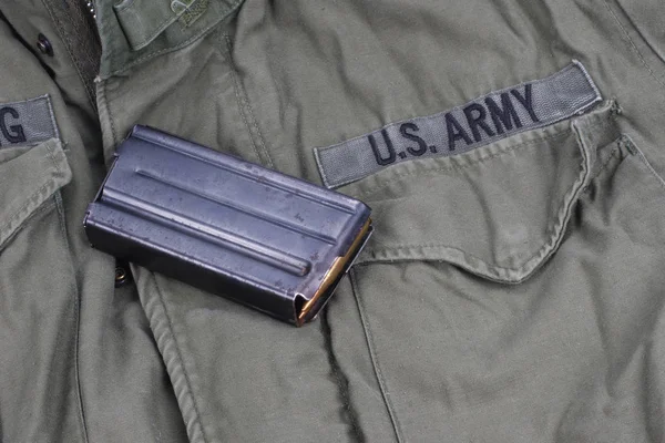 US ARMY M16 Rifle 20rd Magazine Vietnam war period with ammo and dog tags on olive green uniform background
