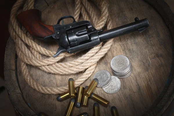 旧的西部左轮手枪与弹药筒和银美元在木桶 — 图库照片