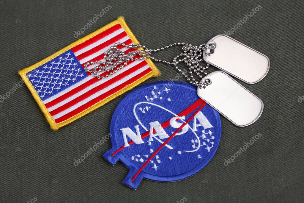 15 March 2018 - The National Aeronautics and Space Administration (NASA) emblem patch, dog tags, and US Flag patch on green uniform background