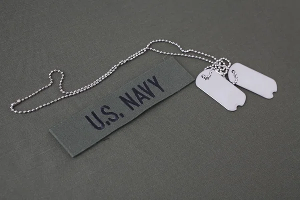 オリーブ グリーンの一様な背景に犬のタグを持つ米国海軍枝テープ — ストック写真